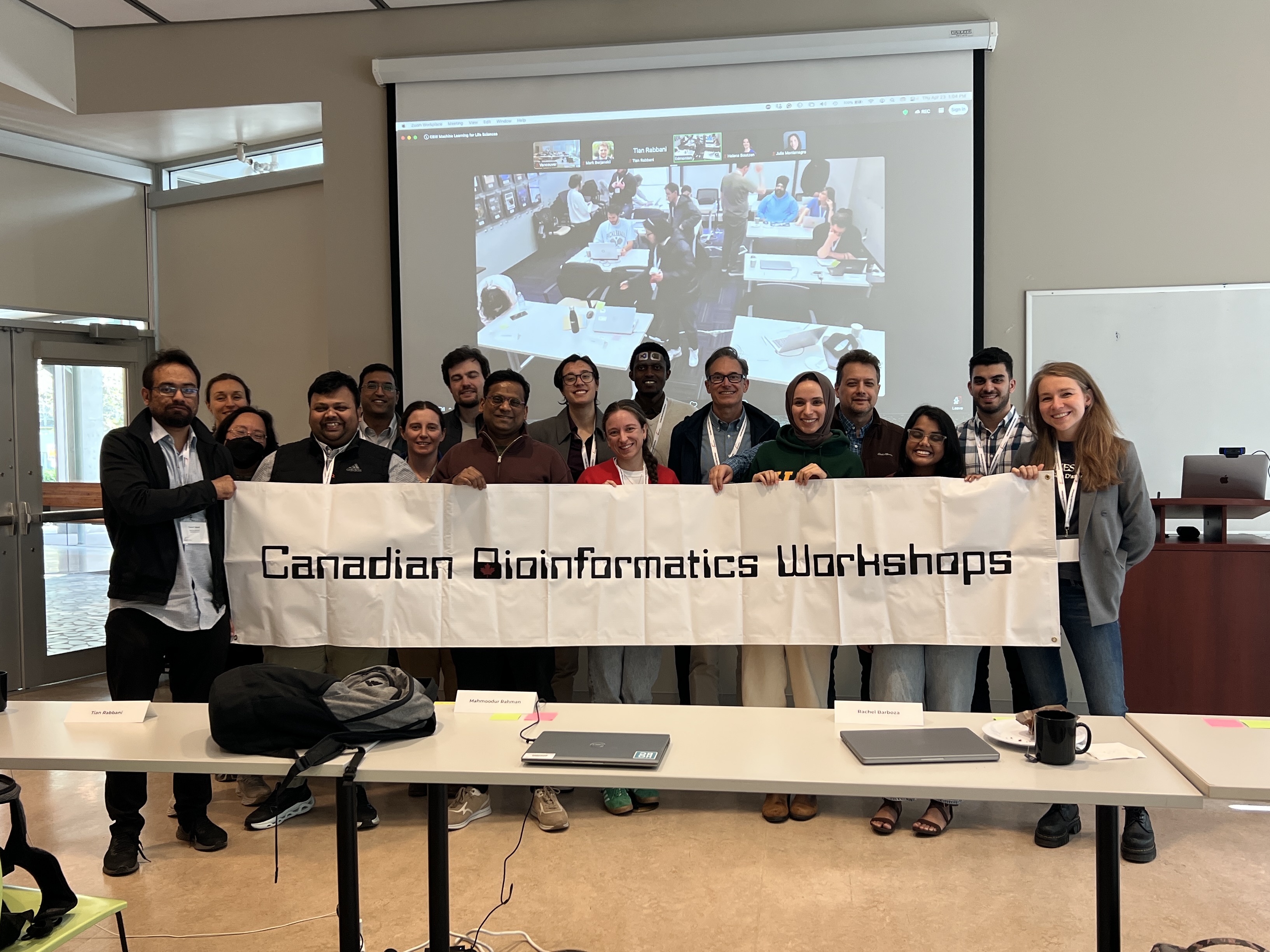Group photo of Vancouver participants standing behind a white banner with black text reading 'Canadian Bioinformatics Workshops'.
